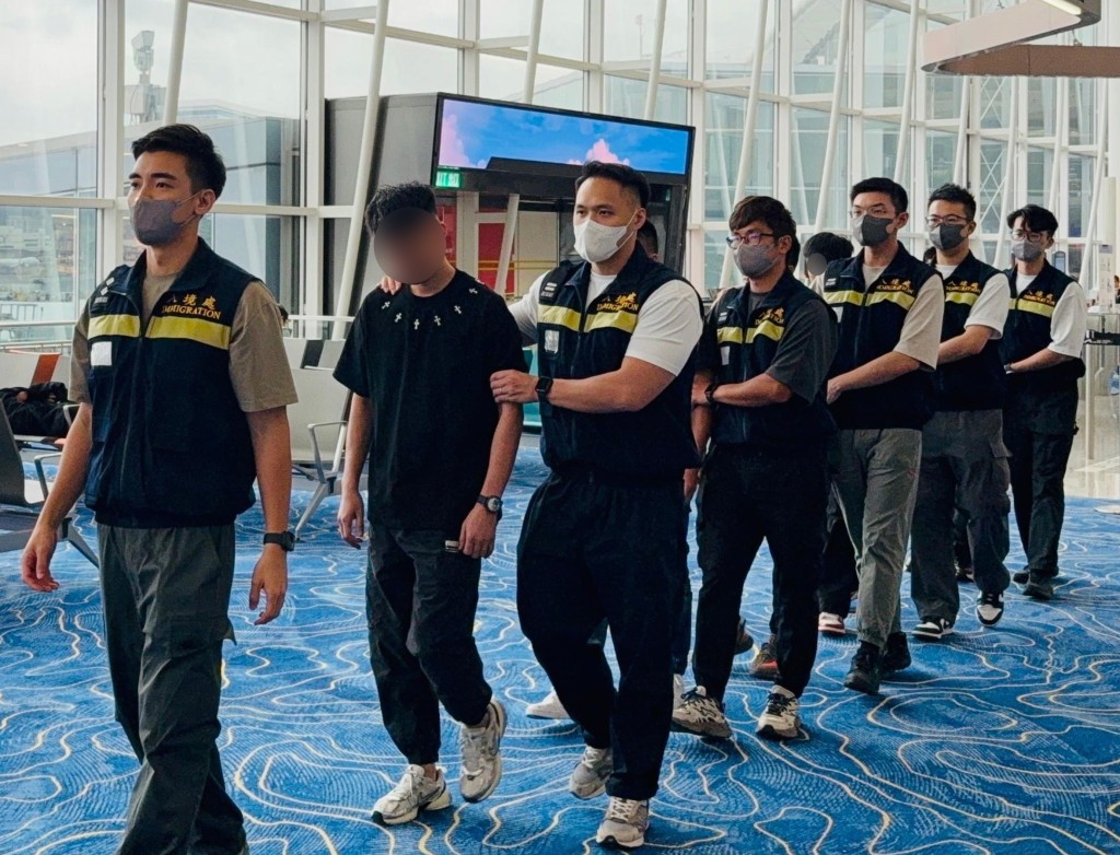 被遣返人士在入境處人員押送下離港。政府新聞處圖片 被遣返人士在入境處人員押送下離港。政府新聞處圖片