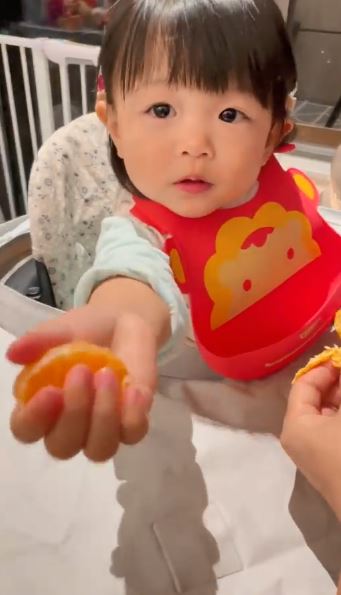 囡囡乖巧也給揸機的媽咪餵食柑。