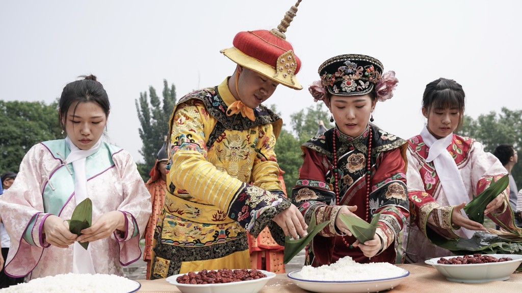 2018年圓明園舉行龍舟表演賽,穿皇服的工作人員在圓明園萬方安和景區為遊客包糭。 中新社 2018年圓明園舉行龍舟表演賽,穿皇服的工作人員在圓明園萬方安和景區為遊客包糭。 中新社