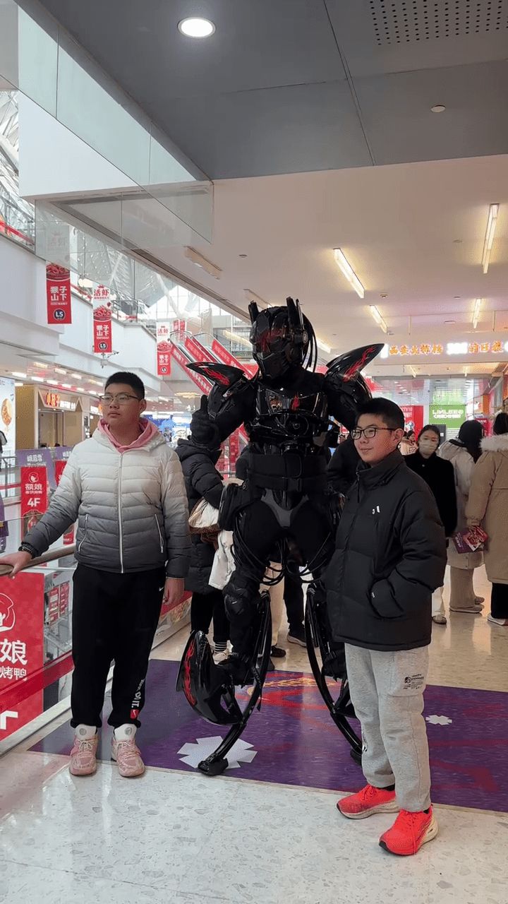 周高賽穿上機甲「戰衣」與民眾合照，令他倍感自豪。 抖音