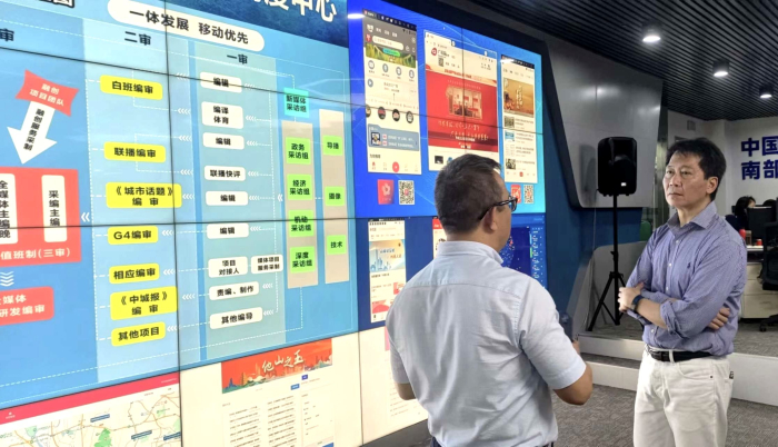 广州市广播电视台向张国财介绍广州最新的5G传送技术。