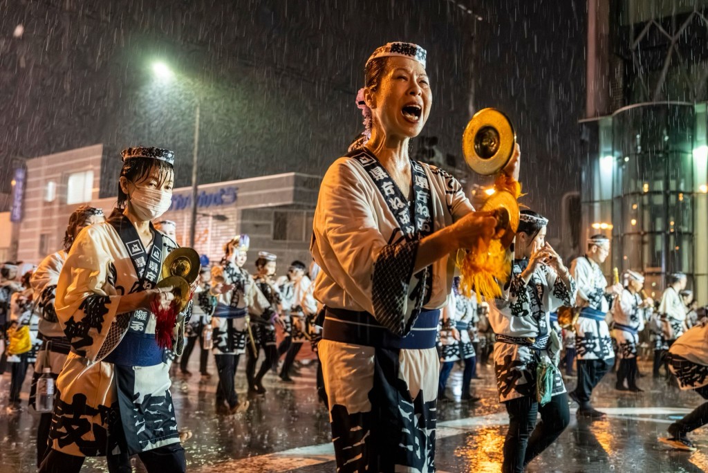 表演期間下大雨，遊行隊伍冒着大雨繼續進行，我則撐着雨傘繼續拍攝。