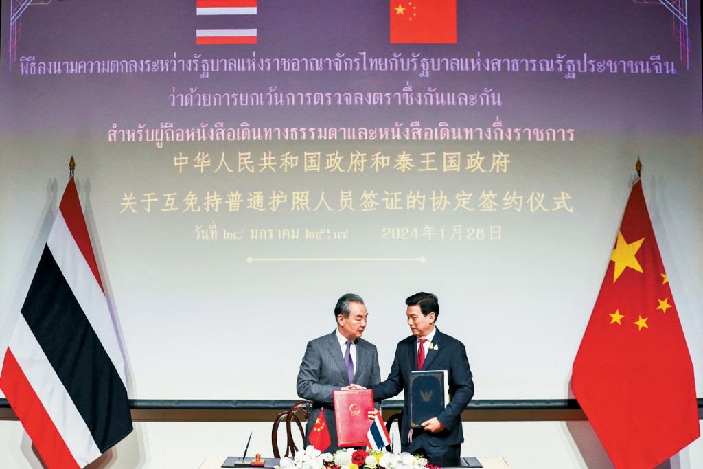 外長王毅(左)和泰國副總理兼外長班比(右)正式簽署永久互免簽證協議。
