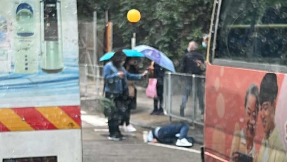 好心市民为受伤男途人撑伞挡雨。马路的事 (即时交通资讯台) Edwin Ying Fai