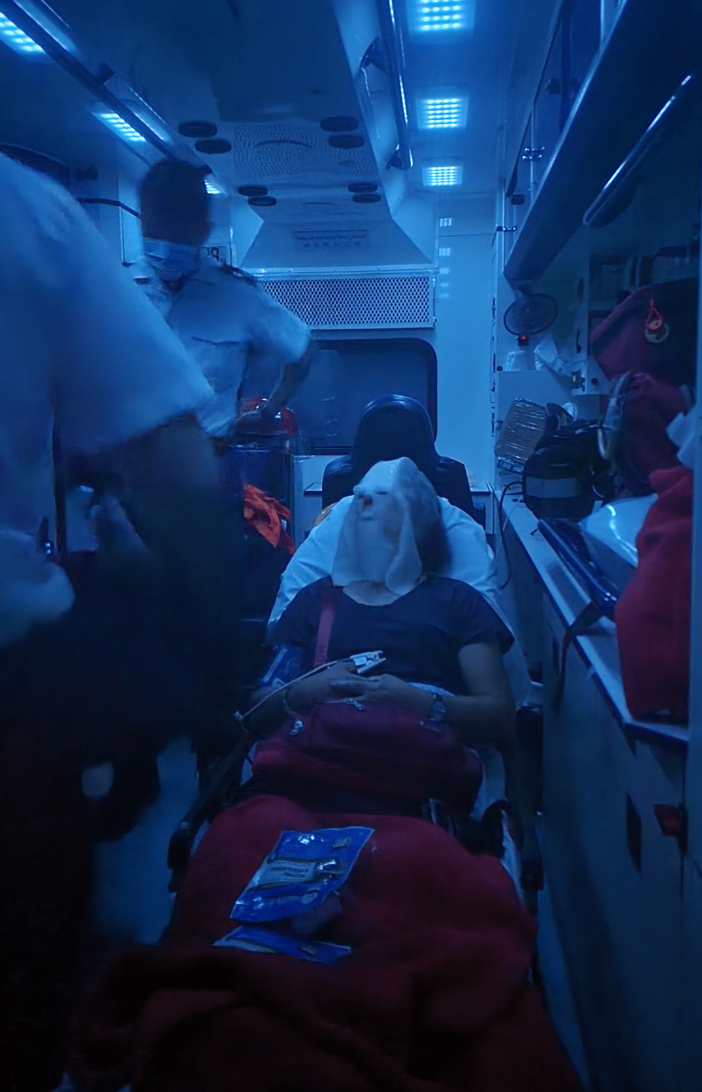 救护员为女事主用防菌面膜敷在面部。