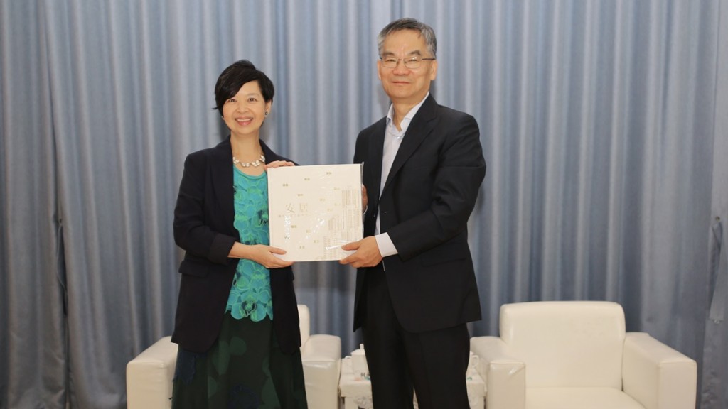 何永賢向從北京專程來到杭州的住房和城鄉建設部總經濟師曹金彪（右）送贈房委會五十周年紀念特刊《安居　攜手走過公營房屋50年》。政府新聞處圖片