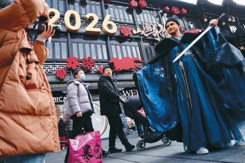 農曆大年初一，一名外籍遊客在上海豫園擺着造型拍照。