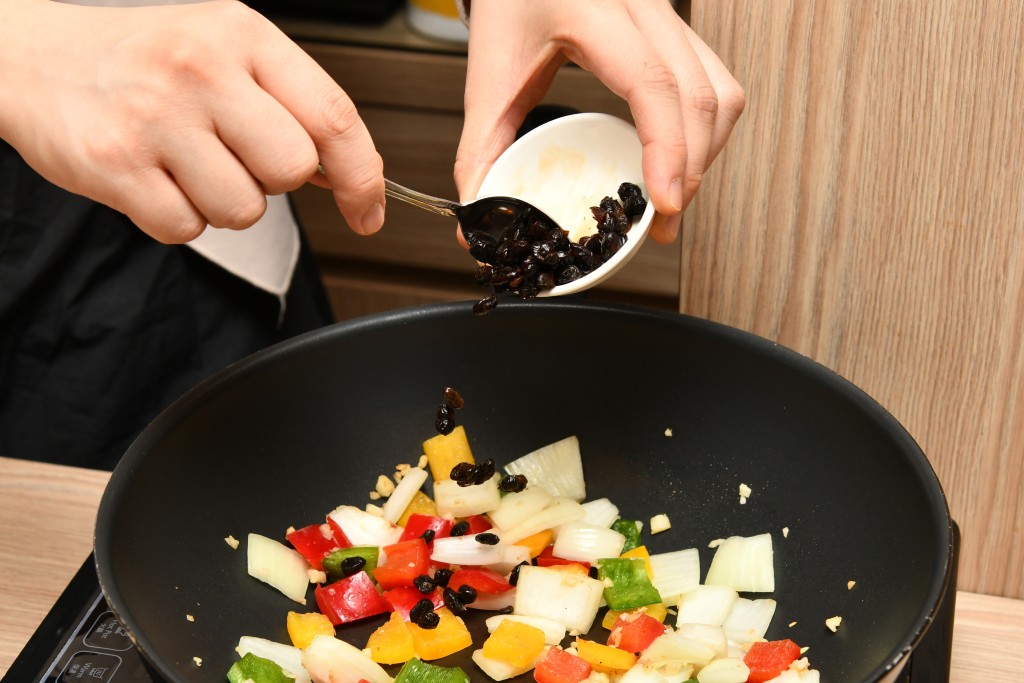 Step 6: 加入豆豉及三色甜椒炒勻。 Add the fermented black beans and bell peppers, stir well.