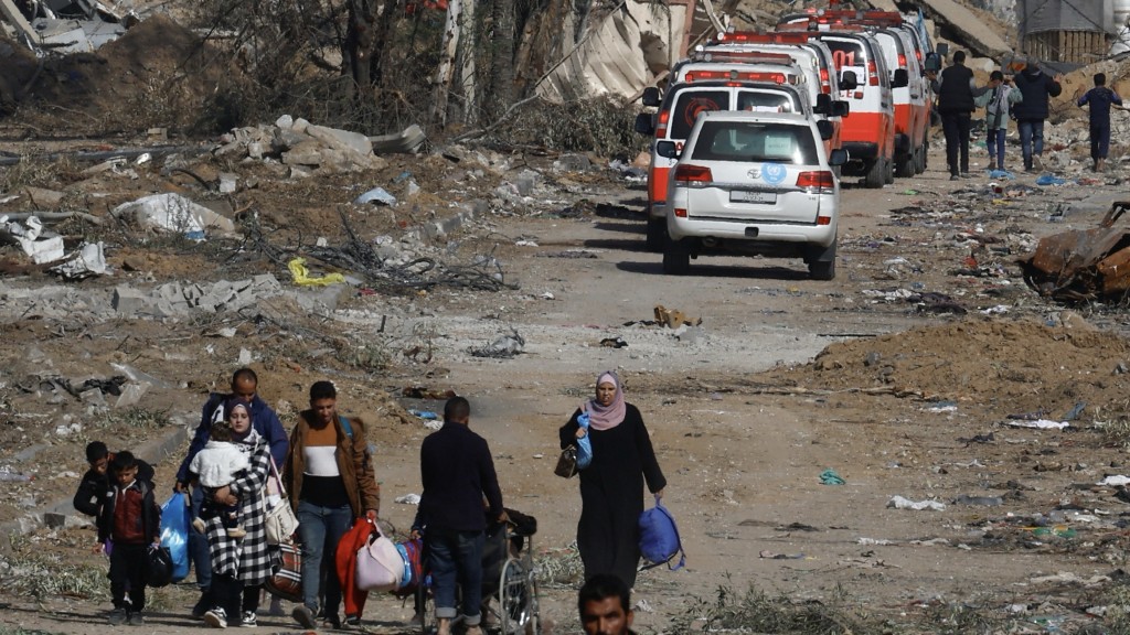 民众逃离加沙城，救护车队则飞奔入城救人。路透社