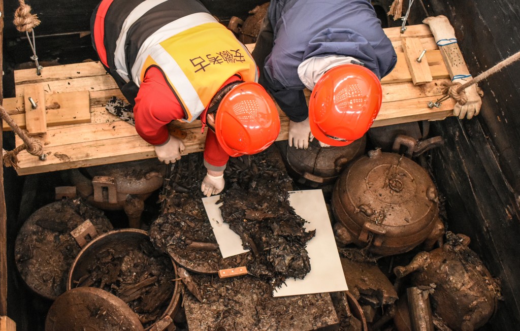 考古工作者在安徽淮南武王墩主墓内提取脆弱的文物。新华社
