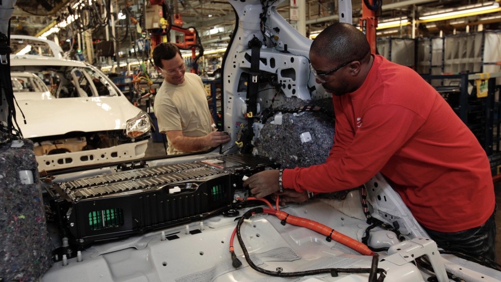 福特汽車裝配工人為2013福特C-MAX 混合動力汽車後部安裝電池組。 路透社