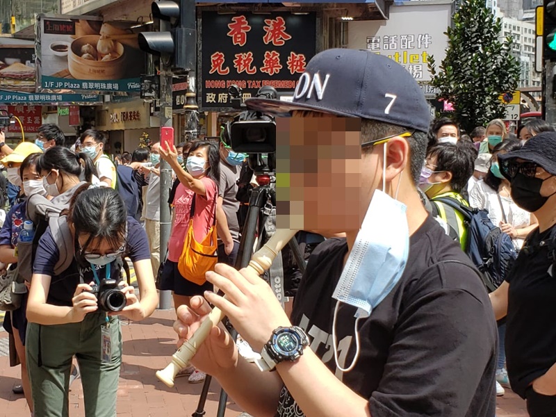 有市民在銅鑼灣街頭吹笛。