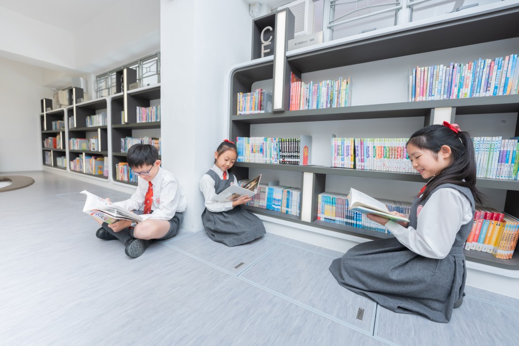 三人在圖書館內各自選看喜歡的課外書，十分投入。（圖片來源：《親子王》）