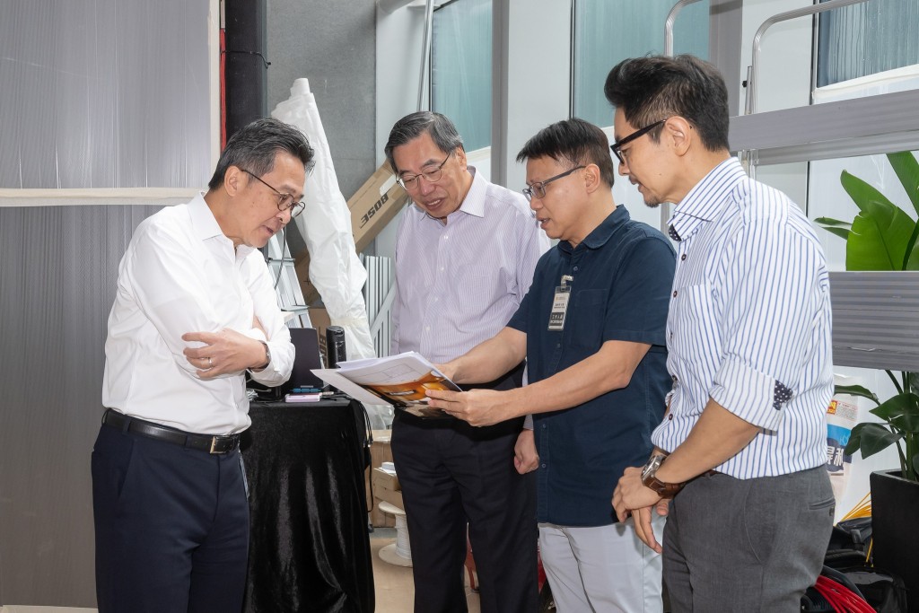 梁君彥(左二)今日和秘書長到大堂了解屏幕的安裝進度和測試音響。