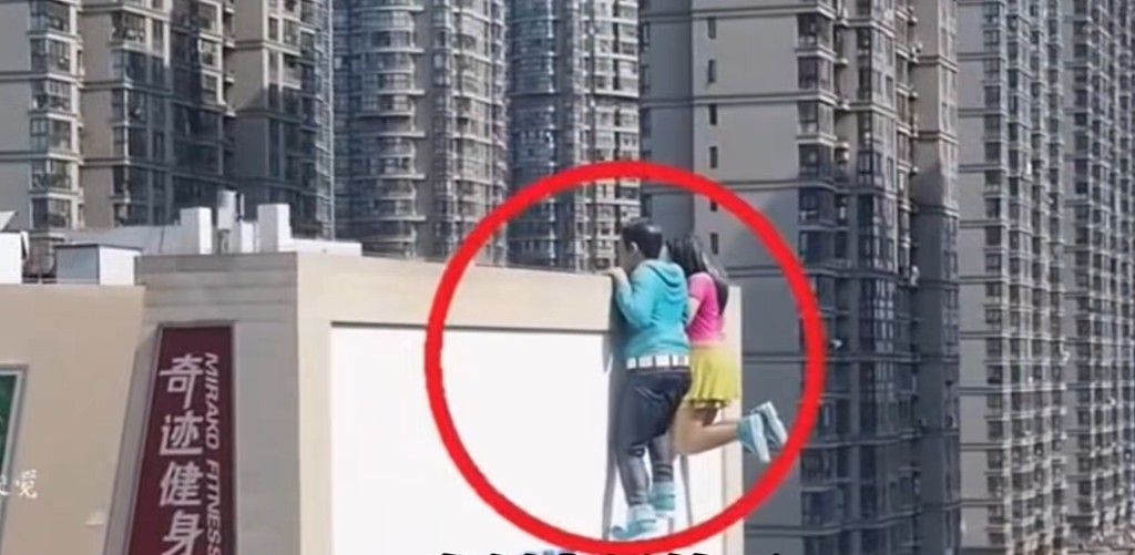 巨大的青年男女以攀爬的姿勢出現商場外牆。