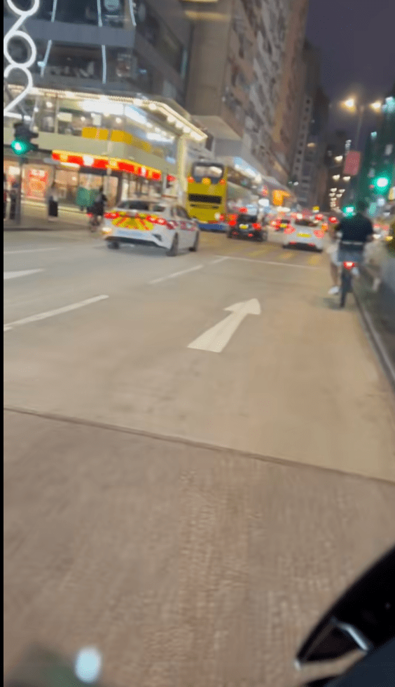 慢線亦有另一名男子駕駛電動單車,兩輛電動單車猶如左右「夾」着警車同行。 慢線亦有另一名男子駕駛電動單車,兩輛電動單車猶如左右「夾」着警車同行。