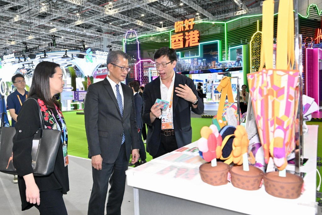 陈茂波在进博会到访香港的参展商展位，听取参展商介绍产品。政府新闻处  ​