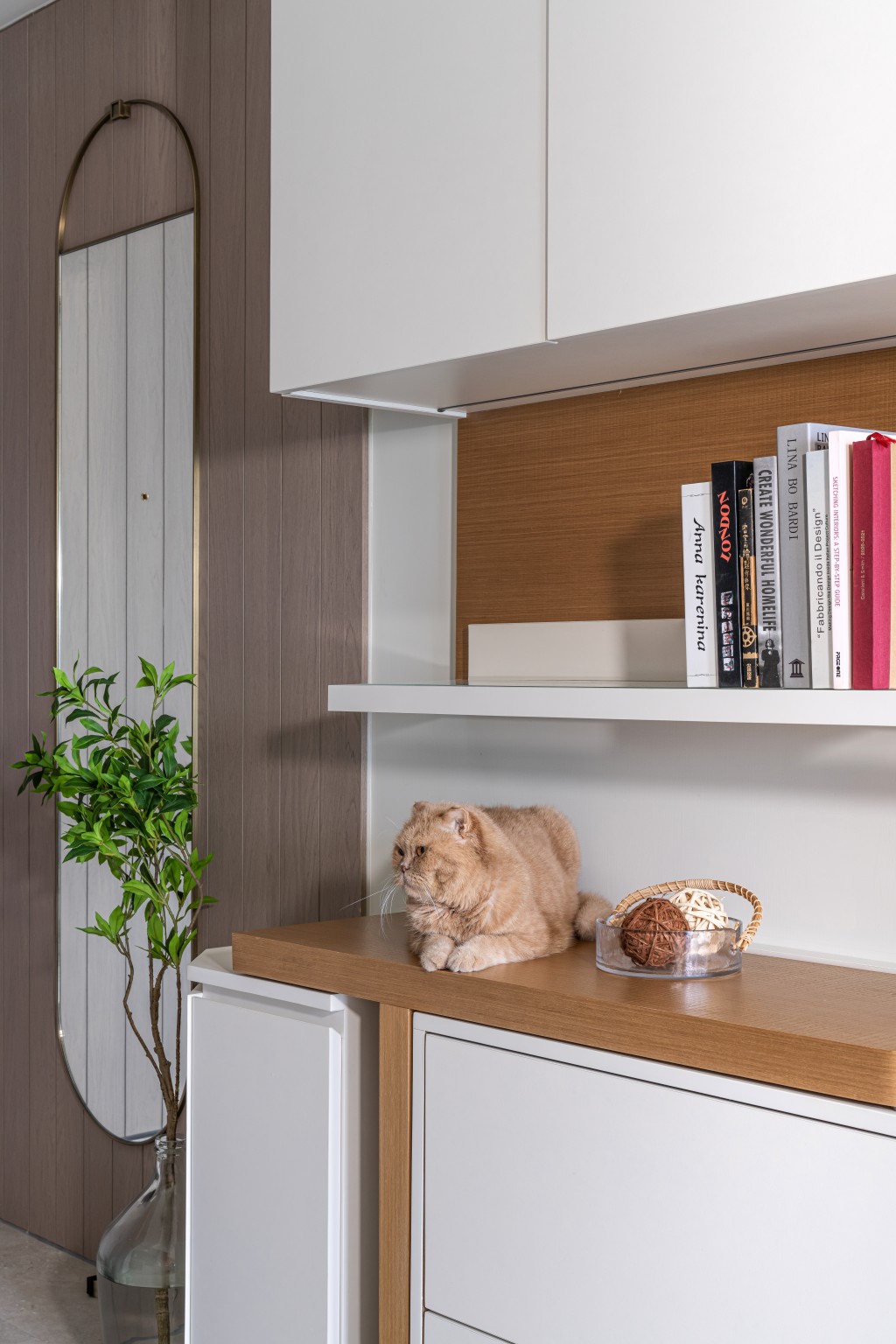 厨房对面有一个白色高身储物柜，视线水平特别设计成中空的装饰层架，减低压迫感。