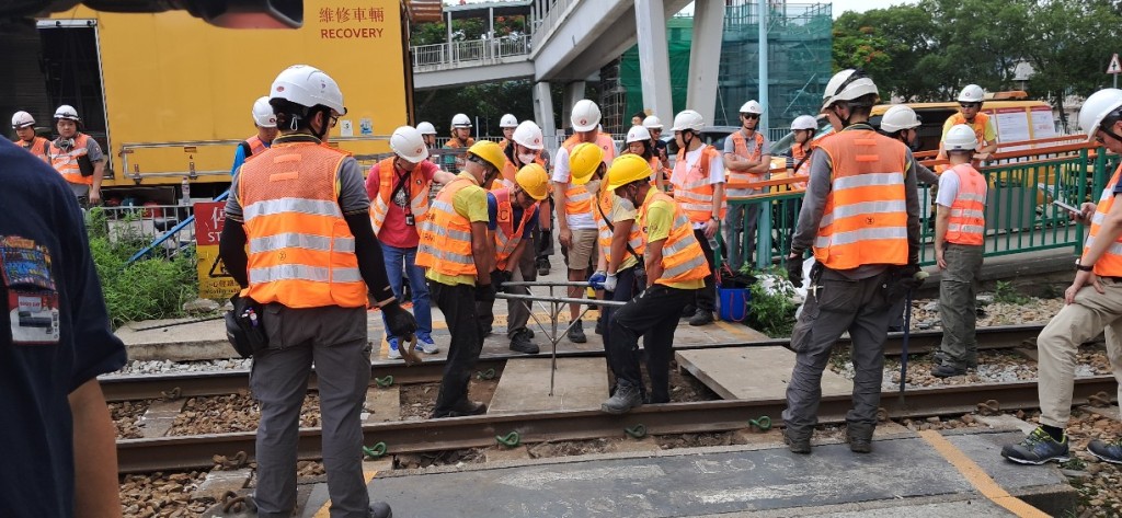 維修工人在鍾屋村站行人過路線重鋪石屎板。林思明攝