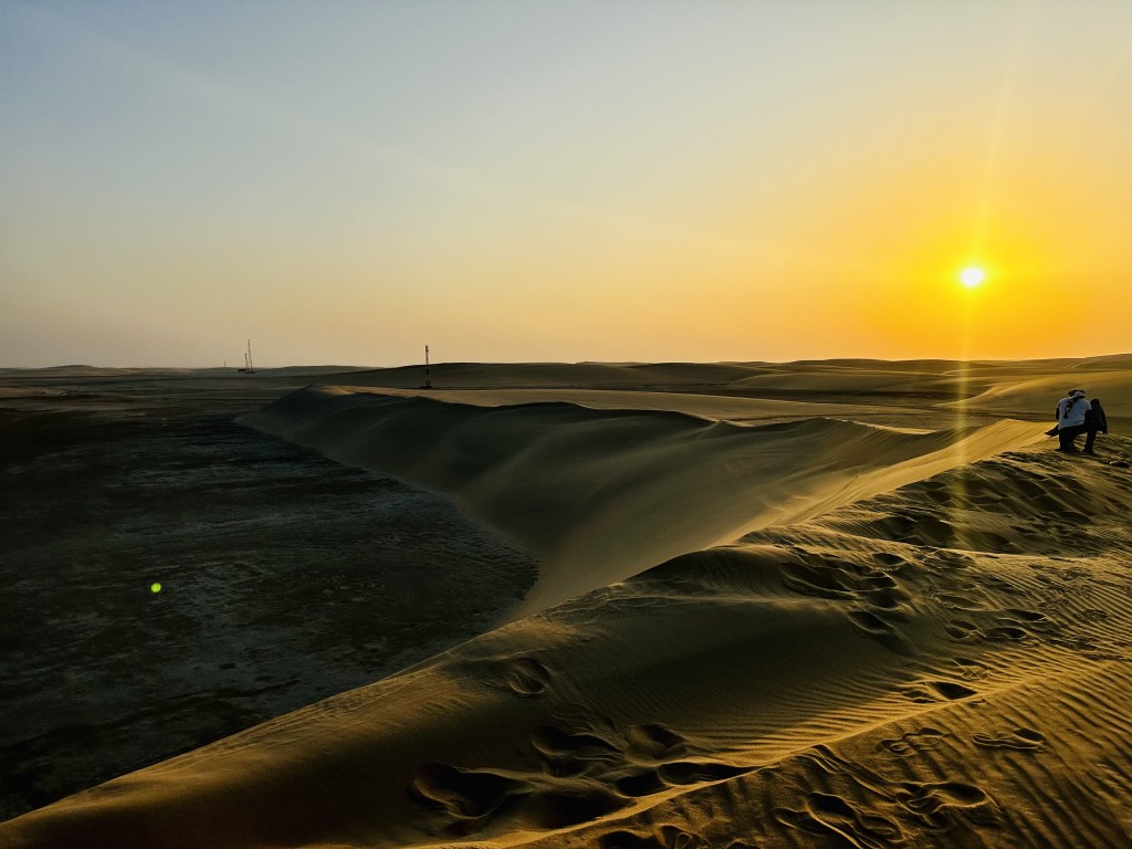 沙漠與海邊連接，在太陽襯托下，就像一幅美麗的圖畫。