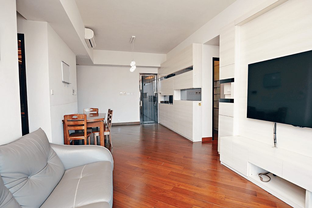 客廳鋪有淺木地板，襯素白牆身及收納櫃，空間舒適。