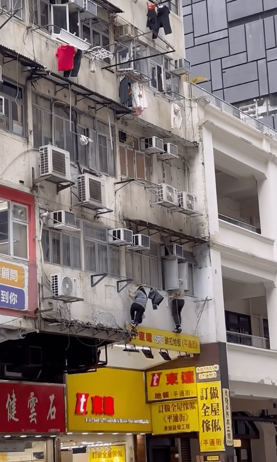 兩人隨後動作利落地縱身爬進單位窗戶，白衣男子先躍身進去。