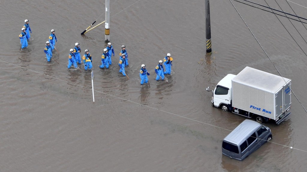 愛知縣豊川市水浸，救援隊伍走到水中央拯救被圍困的汽車。 路透社