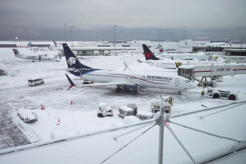 暴风雪导致航班取消和重大延误后，飞机停在温哥华国际机场的登机口。AP