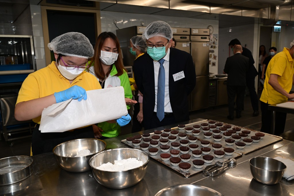 孙玉菡（左三）在典礼后参观职业训练大楼的糕饼工场，了解智障学员接受的餐饮制作训练。