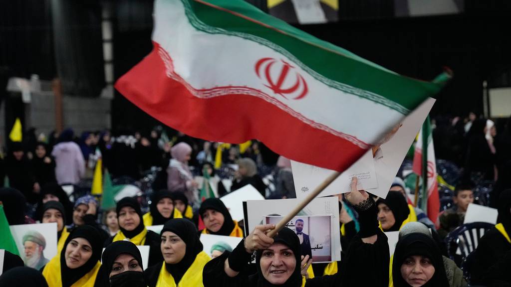 一名真主黨支持者在集會上揮舞伊朗國旗，以示對伊朗政府的支持。 美聯社