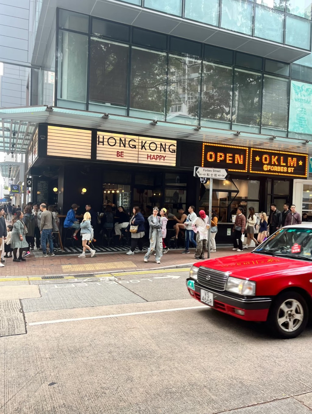 遊客與科士街咖啡店「HONG KONG BE HAPPY」招牌合影。小紅書圖片 遊客與科士街咖啡店「HONG KONG BE HAPPY」招牌合影。小紅書圖片