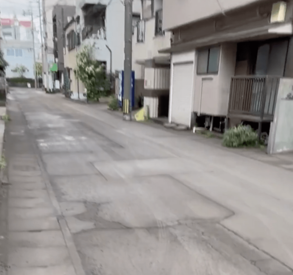 街道两旁的建筑物外墙、行驶中的电车以及停泊在路边的私家车全部“变装”，表面满是灰色泥浆。