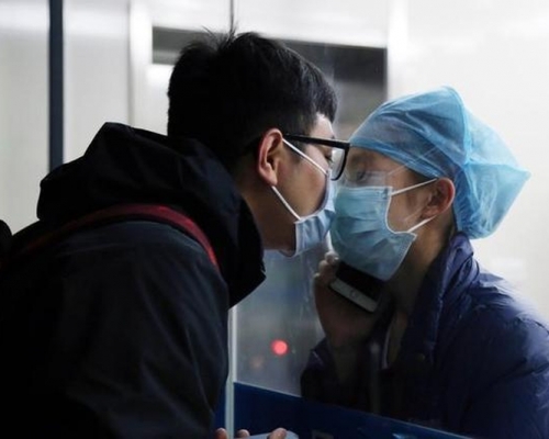 疫情之下的愛情有多浪漫,護士時隔11天隔著玻璃口罩與男友親吻成經典。(網圖)