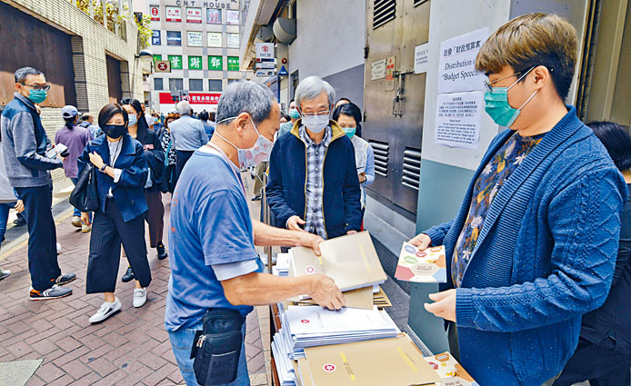 灣仔民政事務處,昨派發預算案刊物,市民都關心預算案內容。
