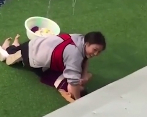 四川一名女幼師涉虐，身體壓在男童身上，小孩大哭還咧嘴笑。（網圖）