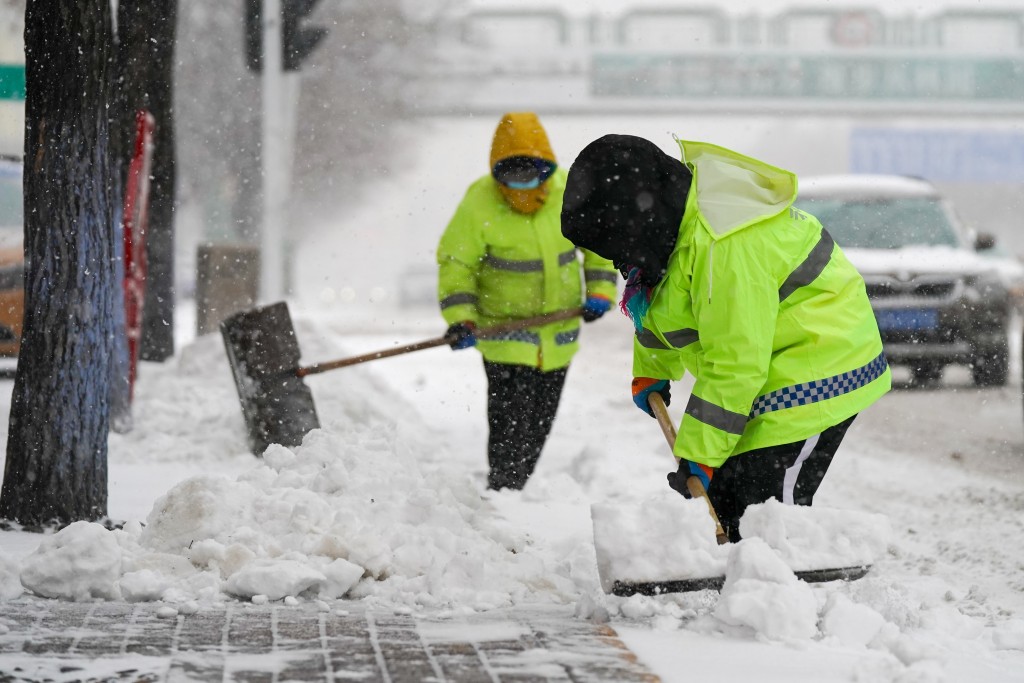 11月6日，环卫工人在街边清雪。当日，黑龙江省哈尔滨市迎来今冬首场暴风雪。 中新社