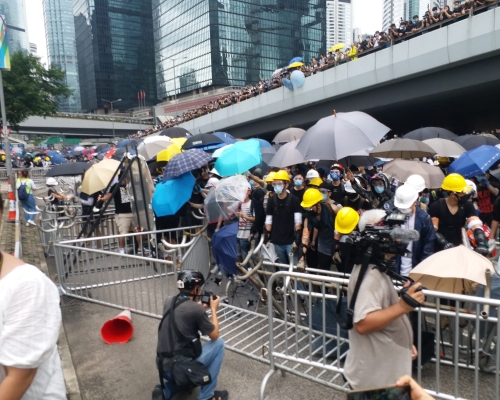 邻近沙中线地盘有建筑工人向示威者提供头盔。