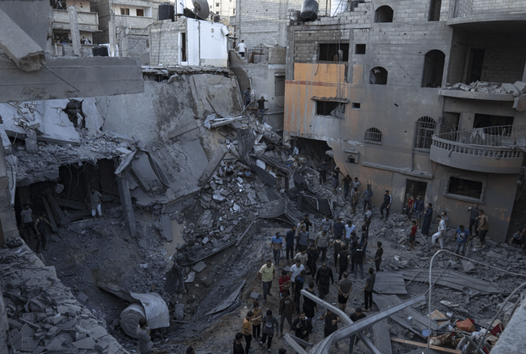 加沙居民在被炮火轰炸的灾场搜救生还者。美联社