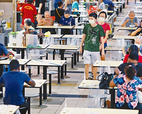 ■新加坡人周二在熟食中心用餐時保持社交距離。