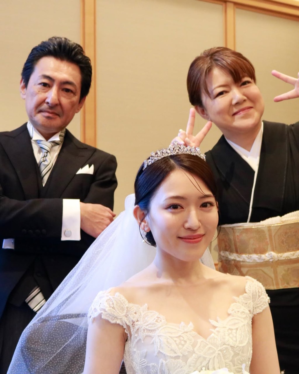 內田真由美與父母合照，媽媽在背後俏皮地舉起V字手勢。