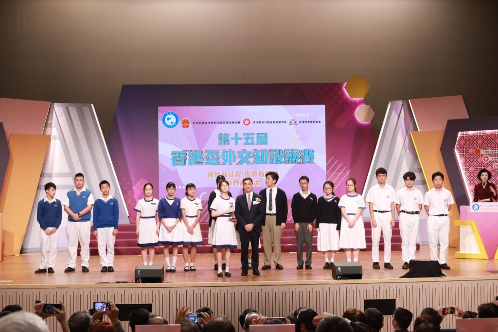 香港賽馬會主席利子厚 （穿西裝者）頒發最佳台風獎予得獎拔萃女書院同學。（馬會提供）
