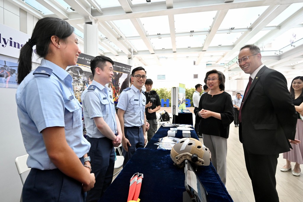 楊何蓓茵（右二）到場參觀政府飛行服務隊設立的攤位。旁為香港浸會大學校長衞炳江（右一）。政府新聞處