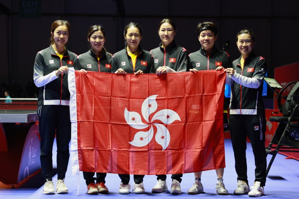 香港女子隊憑杜凱琹（右二）、李皓晴（右一）、朱成竹（左三）取得巴黎奧運入場券後，立即跟教練張瑞（右三）合照。相片：香港乒總