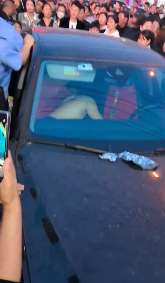 疑是小三女子被扒光上身衣物，被困車內。影片截圖