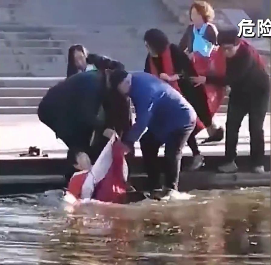 跌落水的大媽，似乎還未完全控制到自己身體，腳步不穩站不起來。