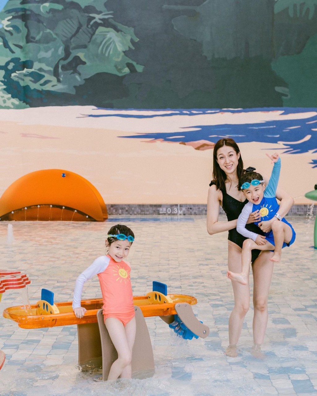 鍾嘉欣身穿一件頭泳裝，與子女一齊玩水。