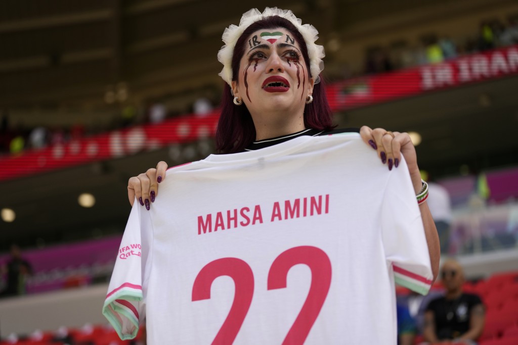 有女球迷在世界杯比赛期间高举印有伊朗库德族女子艾米尼名字的球衣。AP