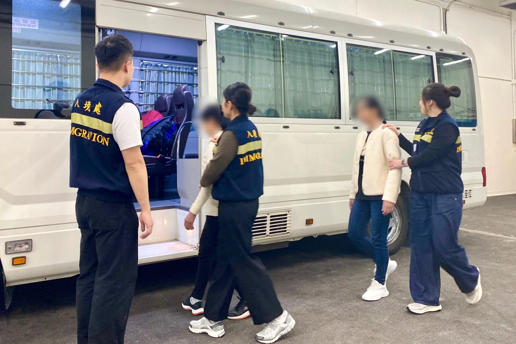 被遣返人士在入境处人员押送下离开羁押地点前往机场。入境处图片