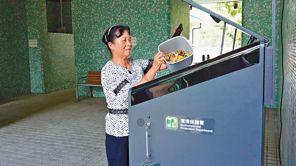 公屋居民黃女士養成回收廚餘習慣，她指邨內的智能廚餘回收桶距離其住所僅需一分鐘路程。黃女士會利用環保署派發的家居廚餘桶盛載廚餘，容易清洗又可以重用。