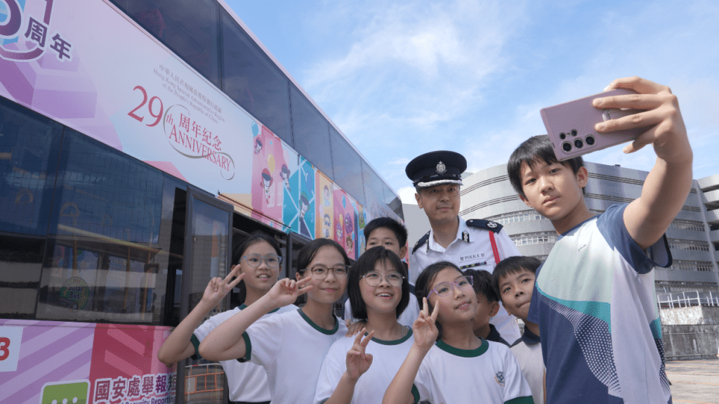 警務處助理處長(國家安全)郭嘉銓與學生們在「國安號」巴士前合照打卡留念。 警務處助理處長(國家安全)郭嘉銓與學生們在「國安號」巴士前合照打卡留念。